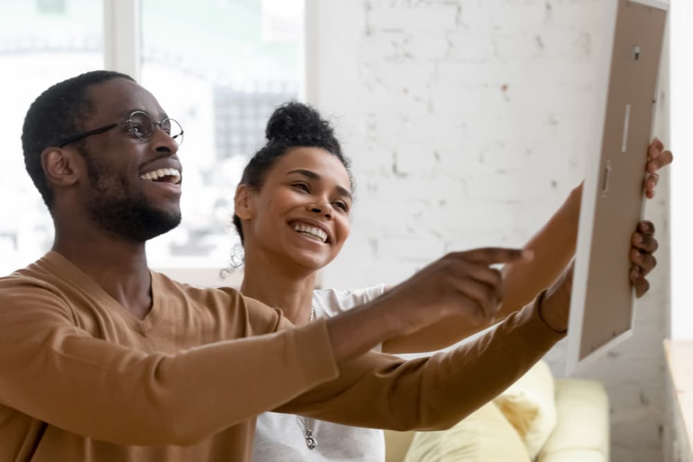 Two people smiling at framed photo